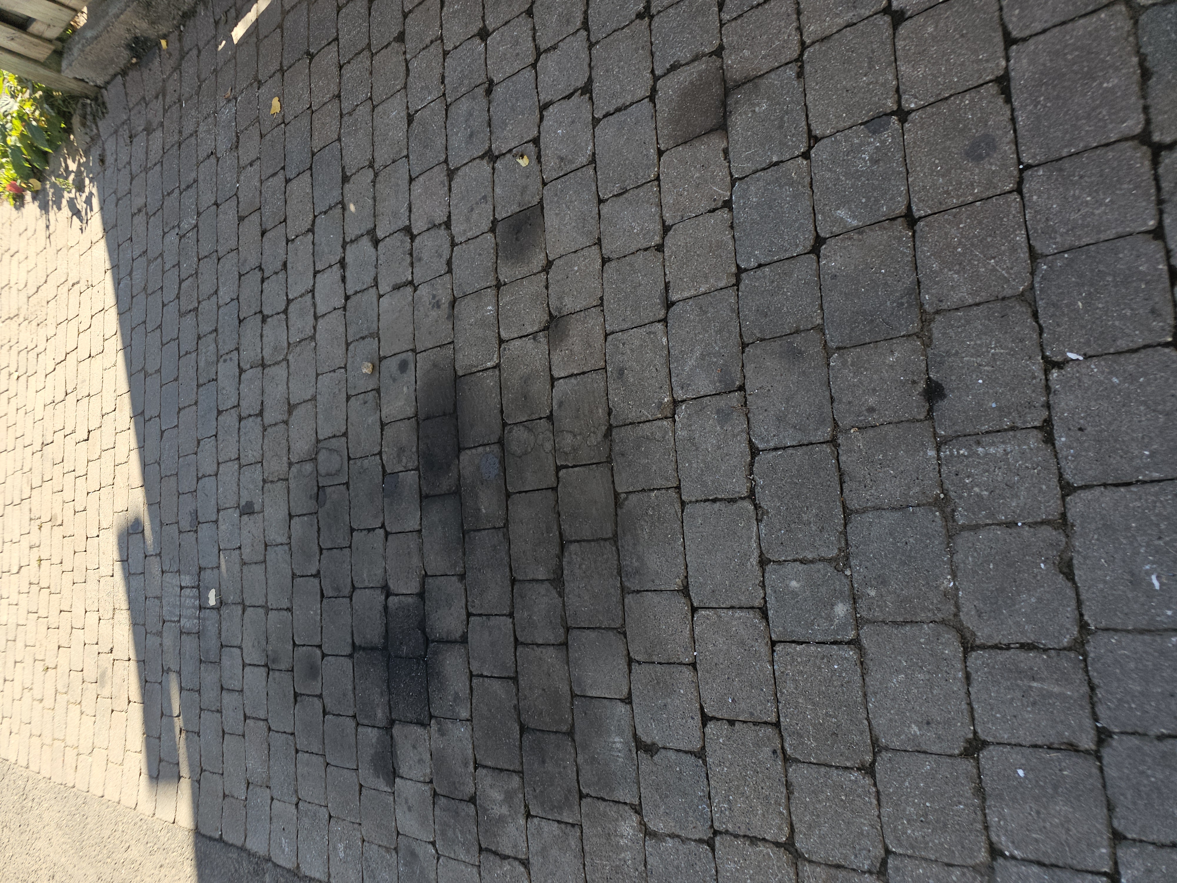 Close-up of dark cobblestone paver driveway after pressure washing